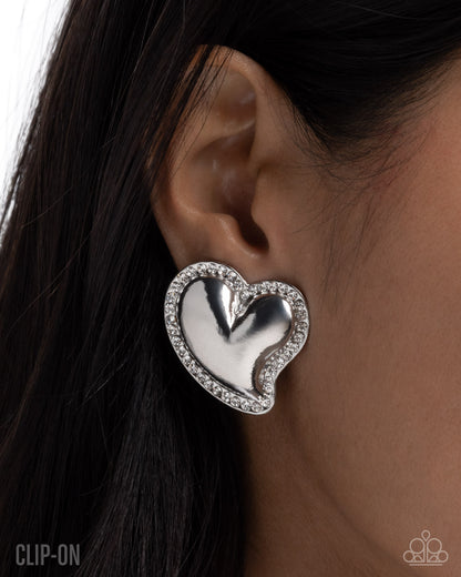 Loveable Luminescent - White Rhinestone, Silver Heart Clip-on Earrings - Paparazzi Accessories